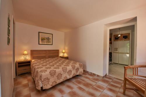 une chambre avec un lit, une table et une chaise dans l'établissement Maison L'Olivier avec piscine, à Cuttoli-Corticchiato