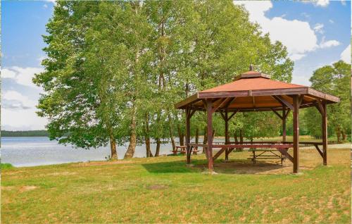 a gazebo in a park next to a lake at Cozy Apartment In Dominikowo With Wifi in Dominikowo