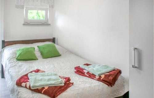 a bed with green and red towels on it at Cozy Apartment In Dominikowo With Wifi in Dominikowo