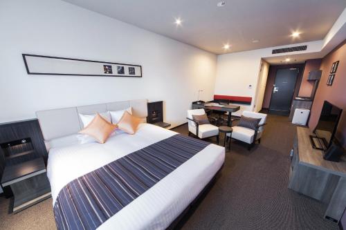 a hotel room with two beds and a television at HOTEL MYSTAYS PREMIER Kanazawa in Kanazawa