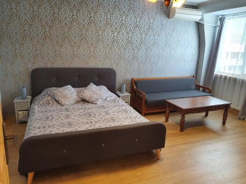 1 dormitorio con 1 cama, 1 silla y 1 mesa en Апартамент Барок 2 en Lovech