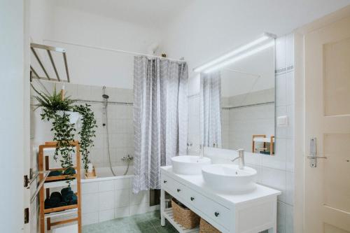 Central Design-Apartment next to Belvedere Castle في فيينا: حمام أبيض مع مغسلتين وحوض استحمام