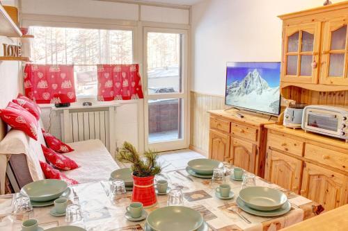 ein Esszimmer mit einem Tisch und einem TV in der Unterkunft Marcolski Home - Schuss 1 in Breuil-Cervinia