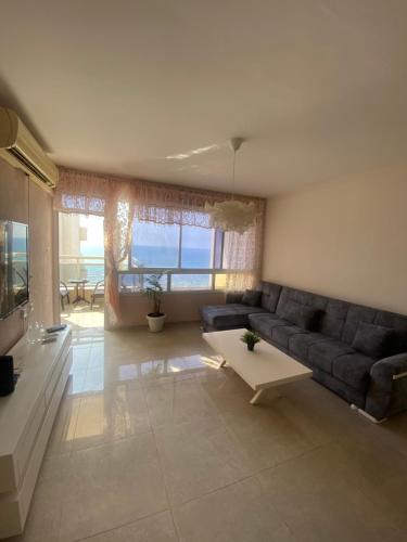 a living room with a couch and a table at Apartment Oskar Beach in Bat Yam