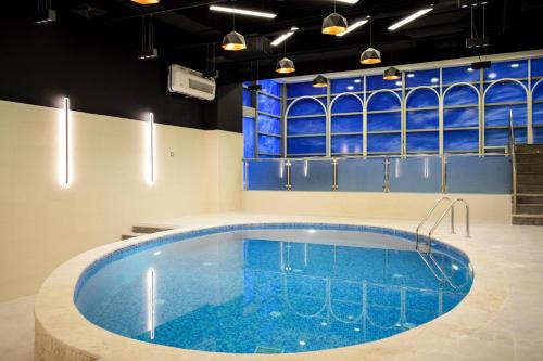 a large swimming pool in a room with blue walls at Saraya Corniche Hotel in Doha