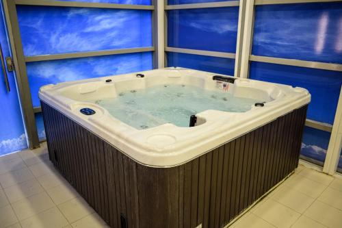 a jacuzzi tub in a room with windows at Saraya Corniche Hotel in Doha