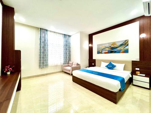 a hotel room with a bed and a chair in it at Khách sạn Ngọc Hà in Lao Cai