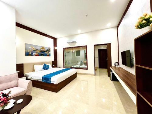 a hotel room with a bed and a couch at Khách sạn Ngọc Hà in Lao Cai