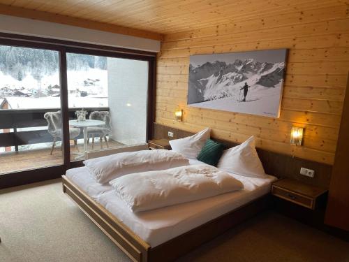 a bedroom with a large bed in a wooden wall at Chalet H Montafon in Gaschurn