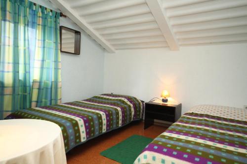 a room with two beds and a table with a lamp at Apartments with a parking space Medulin - 7328 in Medulin