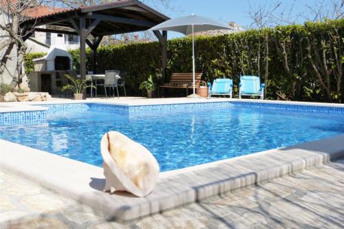 una estatua de delfín sentada junto a una piscina en Family friendly apartments with a swimming pool Valbandon, Fazana - 7346, en Fažana