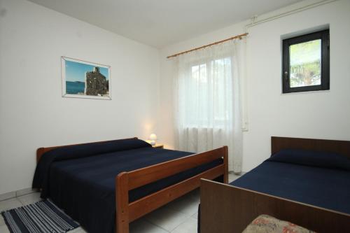 1 dormitorio con 2 camas y ventana en Family friendly apartments with a swimming pool Valbandon, Fazana - 7346, en Fažana