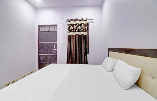 Un dormitorio con una gran cama blanca y una ventana en Hotel Krishna Palace & Restaurant By WB Inn, en Agra