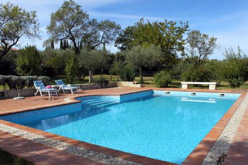 einen Pool in einem Garten mit zwei Stühlen in der Unterkunft Luxury villa with a swimming pool Kavran, Marcana - 7311 in Krnica