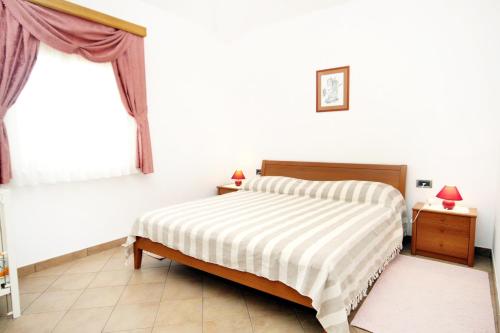 Una habitación blanca con una cama y una ventana en Family friendly house with a swimming pool Kanfanar, Central Istria - Sredisnja Istra - 7330, en Kanfanar