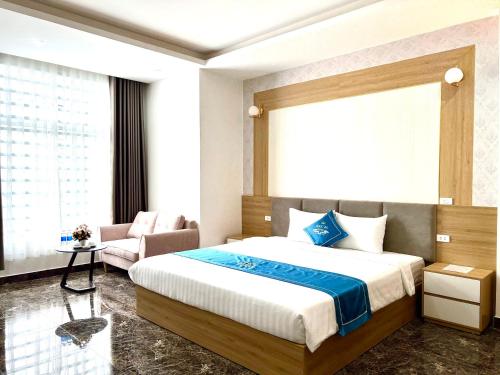 a bedroom with a large bed and a couch at Khách sạn Ngọc Hà in Lao Cai