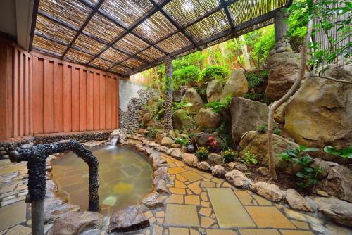 a pool of water in a garden with a fountain at Inasayama Kanko Hotel in Nagasaki