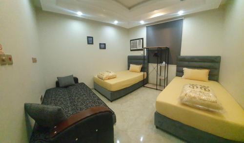 a room with two beds and a chair in it at Kayan Apartments in Jeddah