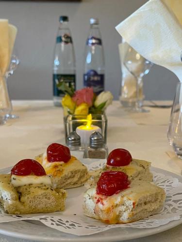 a plate with three pieces of bread with cherries on it at Hotel Berneron in Vallon-Pont-dʼArc