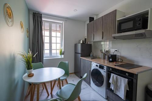 - une cuisine avec une table, une petite table et des chaises dans l'établissement Capstay la Rhonelle - Netflix - 2 chambres - Cuisine, à Valenciennes