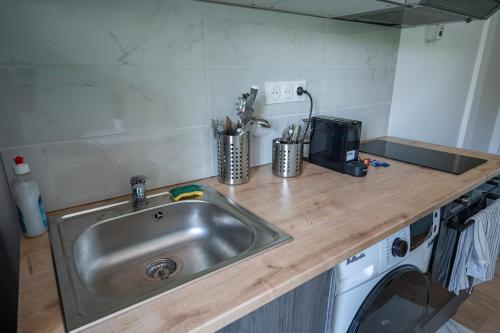 - un comptoir de cuisine avec évier et lave-linge dans l'établissement Capstay la Rhonelle - Netflix - 2 chambres - Cuisine, à Valenciennes