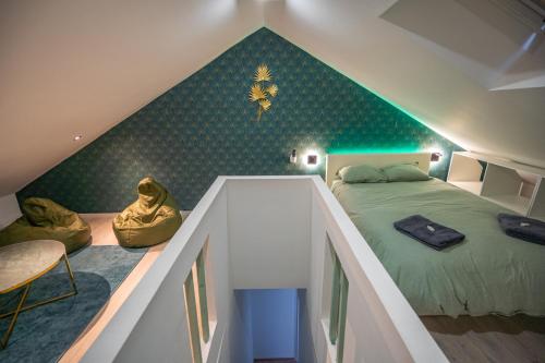 Dormitorio en el ático con cama y pared verde en Capstay la Rhonelle - Netflix - 2 chambres - Cuisine, en Valenciennes