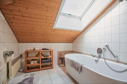 baño con bañera blanca y tragaluz en Schwarzwald Ferienwohnung Stefan *Idyllische Lage *Sauna *Luftkurort *Wanderwege, en Loßburg