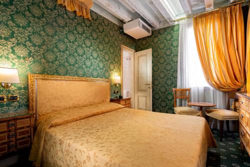a bedroom with a bed and green wallpaper at Hotel Santa Marina in Venice