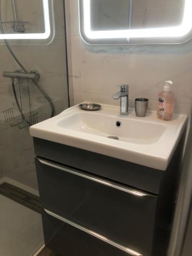 une salle de bain avec un lavabo blanc et une douche dans l'établissement App T2 cozy Proche de la Mer, au Golfe-Juan