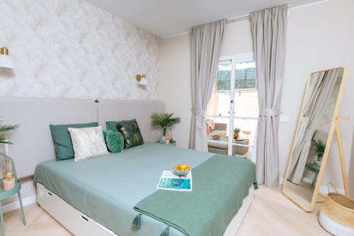 1 dormitorio con cama con espejo y ventana en Amazing renovated pool view Apartment, 2 min to Fañabe Beach, en Adeje
