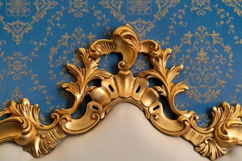 a gold mirror hanging on a blue wall at Hotel Santa Marina in Venice