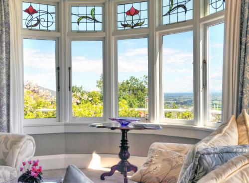a room with a table in front of windows at Dyers House in Christchurch