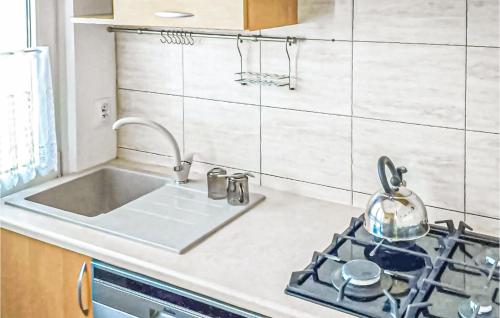 a kitchen with a sink and a stove at 2 Bedroom Cozy Apartment In Koszalin in Koszalin
