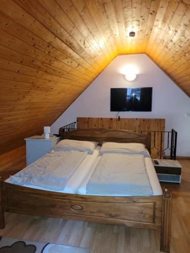 a bedroom with a wooden bed in a attic at Mohás Vendégház Kőszeg in Kőszeg