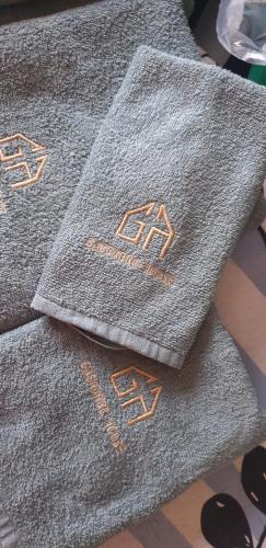 two gray towels with gold writing on them at Gasparro House in Turi