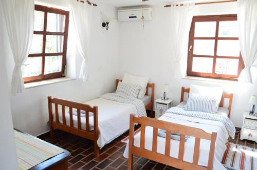 a room with two beds and two windows at Three sisters in Rudine