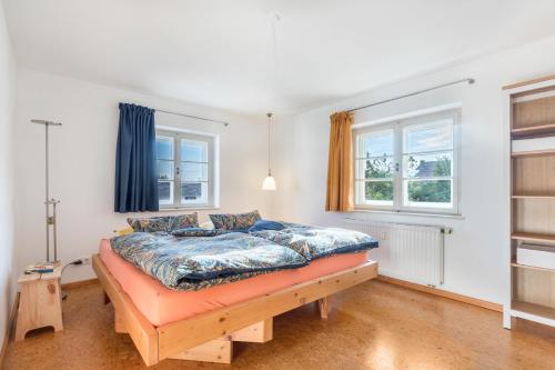 a bedroom with a bed and two windows at 2rad-freunde in Brannenburg