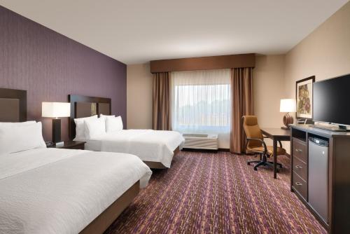 a hotel room with two beds and a desk at Holiday Inn Express Hotel & Suites Billings by IHG in Billings