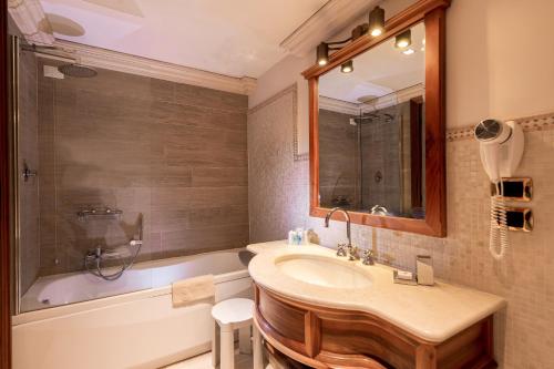 a bathroom with a sink and a tub and a mirror at Hotel Santa Marina in Venice
