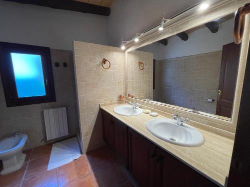 a bathroom with two sinks and a mirror and a toilet at Nostra Caseta villa with pool & marina view near beaches in Cielo de Bonaire 