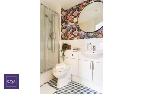 uma casa de banho com um WC e um espelho. em CAYA Living 3BR Apartment in Central Windsor Berkshire - Legoland - Windsor Castle - Lapland UK - Heathrow Sleeps 6 - Private Gated Parking em Windsor