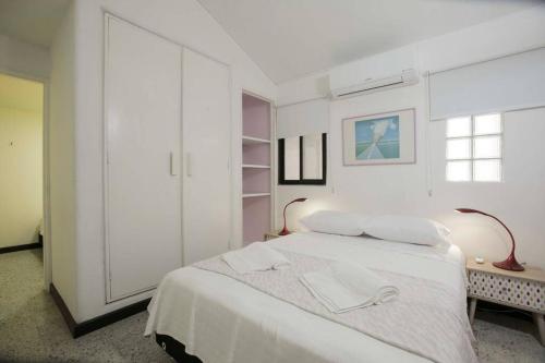 biała sypialnia z białym łóżkiem i oknem w obiekcie Casa Mandala en Los Cristales w mieście Cali