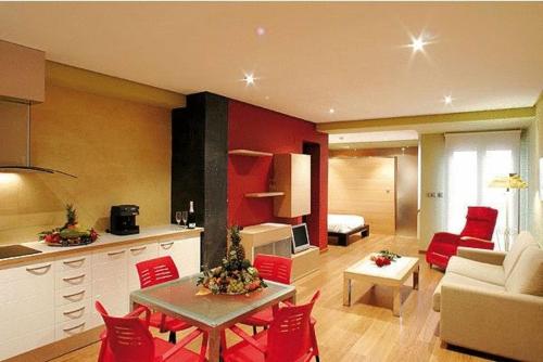 a kitchen and living room with a table and red chairs at Hospedium Apartamentos Cañitas Maite Familiar in Casas Ibáñez