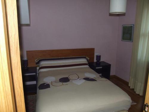 a bedroom with a bed with white sheets and glasses on it at APARTAMENTO ARCE I en el Valle de Benasque in Castejón de Sos