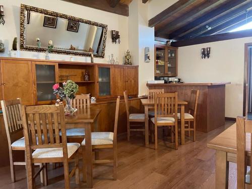 a dining room with a table and chairs and a mirror at Hotel Rural Foncubierta in Soto del Barco