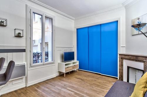 - un salon avec une grande porte coulissante bleue dans l'établissement Studio Quinault - Welkeys, à Paris