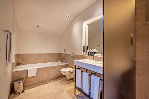 a bathroom with a tub and a toilet and a sink at Boutique Hotel Pellas in Vella
