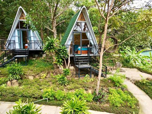 una piccola casa con un tetto verde in un giardino di Homestay De la Rosa - Côn Đảo a Con Dao