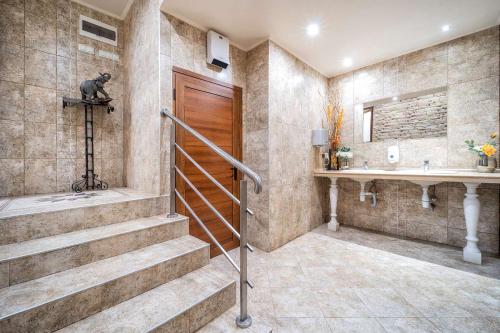 uma casa de banho com uma escada, um chuveiro e um lavatório. em Hotel Rivera em Dobrich