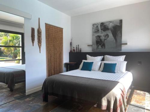 a bedroom with a large bed with blue and white pillows at Chambre SOKA in Urrugne